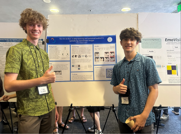 Photo of Alex presenting a research poster.